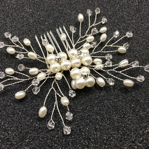 Détail d'un peigne de mariée fait main avec perles et cristaux sur fil d'argent
