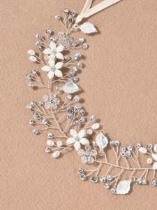 Dettaglio di tralcio per capelli sposa con fiori bianchi, perle e cristalli su filo argento