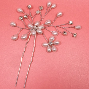 Detail of silver bridal hair pin with white pearls and sparkling crystal flowers