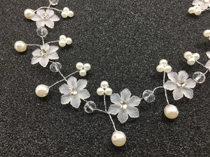 Détail du bandeau de mariée avec fleurs givrées, perles et cristaux sur fil