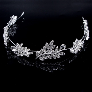 Detailed view of silver bridal headpiece featuring crystal leaves and rhinestones