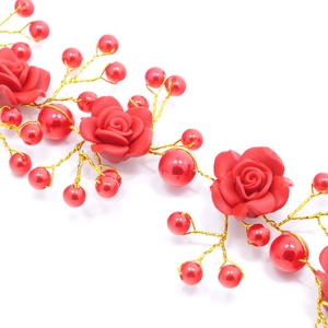 Detail of red clay roses and glossy pearls woven on gold bridal hairband wire