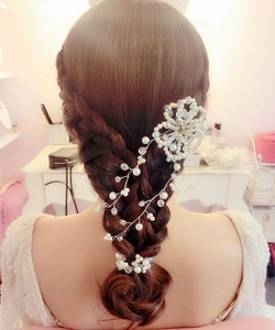 Rear view of a bride wearing an elegant pearl and crystal flower bridal hair vine headband
