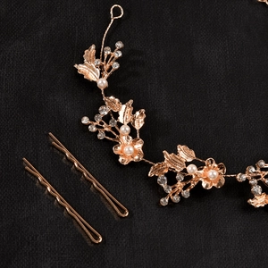 Detail of rose gold bridal hairband with crystal flowers and elegant white pearls