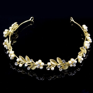Close-up of golden bridal headband with pearl flowers and sparkling rhinestone details