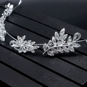 Macro shot of bridal hairpiece featuring silver leaves and sparkling pear-cut rhinestones