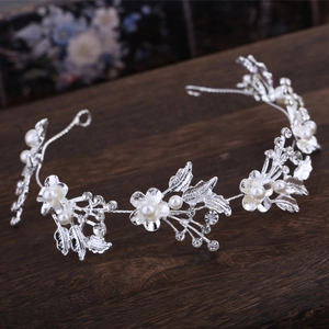 Close-up detail of silver bridal headband with crystal flowers and white pearls