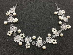 Détail d'un bandeau de mariée artisanal avec fleurs dépolies et perles blanches de luxe