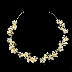 Detail of golden bridal headband with pearls, rhinestones, and delicate flower design