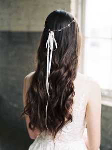 Detail of handmade pearl bridal headband with white silk ribbon on long wavy hair