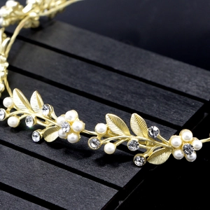 Macro detail of bridal gold leaf headband with faux pearls and sparkling rhinestones