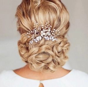 Detail eines Braut-Haarkamms mit Perlen und Strass auf einer eleganten Hochsteckfrisur