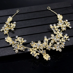 Detailed close-up of golden bridal headband featuring sparkling rhinestones and leaf motifs