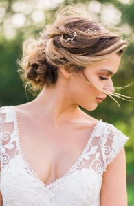 Close-up of handmade pearl bridal headband with gold wire on a bride in white lace gown