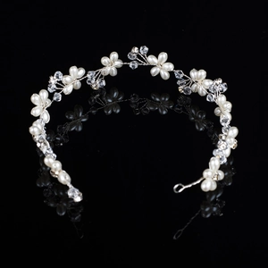 Silver bridal headband with handmade pearls and crystal flowers on reflective background