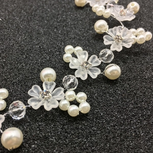 Détail d'une vigne de cheveux de mariée avec fleurs givrées, perles et cristaux