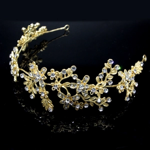 Macro detail of golden bridal headpiece with sparkling crystal leaves and floral patterns