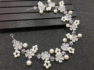 Détail d'un bandeau de mariée fait main avec pétales givrés, perles et fil d'argent