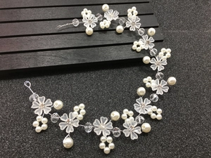 Détail de vigne à cheveux mariée avec fleurs givrées, perles et cristaux sur fil argent