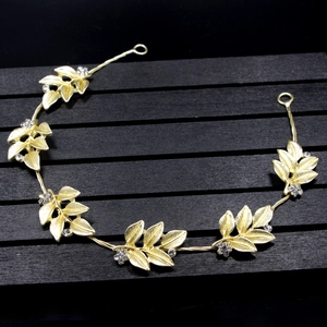 Detailed view of golden olive leaf bridal headband with sparkling rhinestone accents