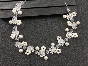 Détail du bandeau de mariée avec fleurs givrées et perles blanches sur fil d'argent