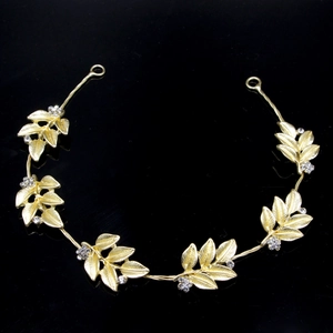 Macro detail of golden leaf bridal headpiece with sparkling crystals and metal texture