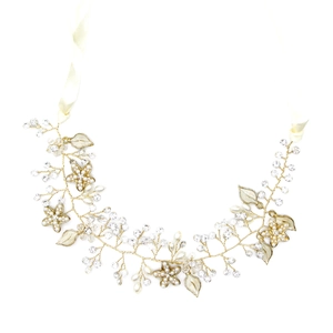 Dettaglio dell'accessorio sposa dorato con fiori in smalto bianco e perle fini
