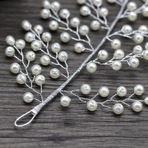 Détail d'un peigne à cheveux de mariée fait main avec perles et motifs de feuilles