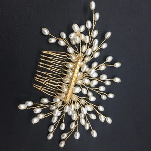 Détail d'un peigne de mariée doré avec perles blanches élégantes sur fond sombre