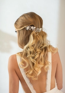 Dettaglio della fascia da sposa con fiori di ceramica bianca e perle su capelli biondi