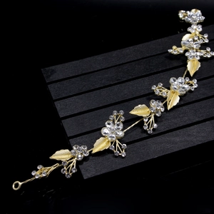 Detail view of golden leaf and crystal flower accents on this elegant bridal headband
