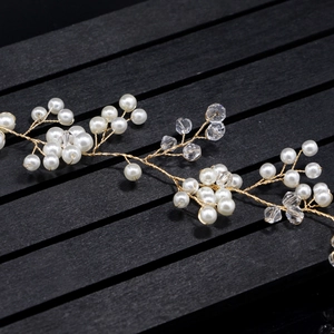 Détail d'un bandeau de mariée artisanal avec perles et cristaux sur support bois foncé