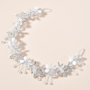 Détail de vigne de cheveux de mariée argentée avec fleurs en cristal et perles