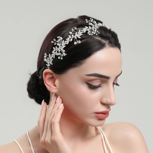 Dettaglio di una fascia da sposa con perle e strass su acconciatura elegante