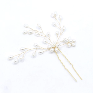 Détail de l'épingle à cheveux de mariée avec perles et design floral en fil doré