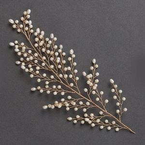 Détail d'un peigne de mariée fait main avec fil doré et perles blanches