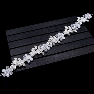 Détail de la vigne à cheveux argentée avec fleurs en cristal et perles sur fond sombre