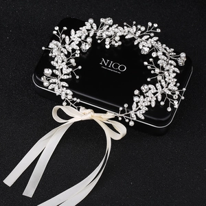 Dettaglio del cerchietto da sposa in argento con perle, strass e nastri di raso bianco