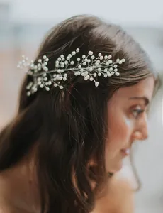 Gros plan détaillé sur un peigne à cheveux en perles et feuilles pour la mariée