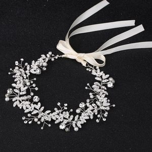 Dettaglio accessori sposa con filo d'argento, strass scintillanti e perle bianche