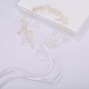 Détail de vigne de cheveux de mariage faite main avec perles, cristaux et rubans blancs