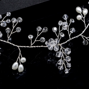 Macro d'un bijou de tête de mariée en argent avec cristaux et perles sur fond noir brillant