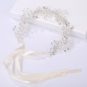 Dettaglio della fascia da sposa con strass scintillanti, perle e nastri di raso bianco