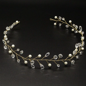 Close-up of handmade bridal hair vine with white pearls and crystals on gold wire