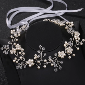 Détail d'un bandeau de mariée fait main avec perles, cristaux et ruban de fixation blanc