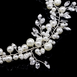 Détail de vigne à cheveux mariée argentée avec perles blanches et feuilles en cristal
