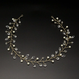 Detail of bridal hair vine featuring white pearls and crystals on gold wire