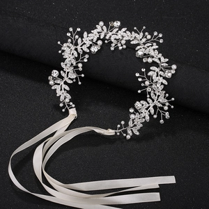 Dettaglio della fascia da sposa argentata con strass scintillanti e perle bianche