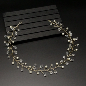 Close-up of handmade bridal headband with white pearls and crystals on gold wire