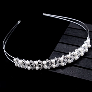 Détail d'un serre-tête de mariée argenté avec strass brillants et perles blanches